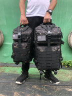 Tactical MOLLE rucksack pair in dark camouflage, front flap pockets and U.S. flag patch