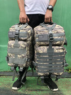 Tactical MOLLE rucksack pair in desert camouflage with front flap pockets and U.S. flag patches
