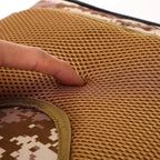 Tactical backpack mesh-padded strap and desert camo seam detail.