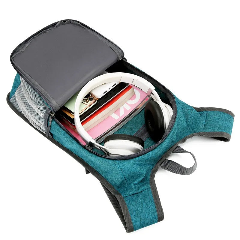 Teal crossbody bag with compartments containing electronic devices on a white background