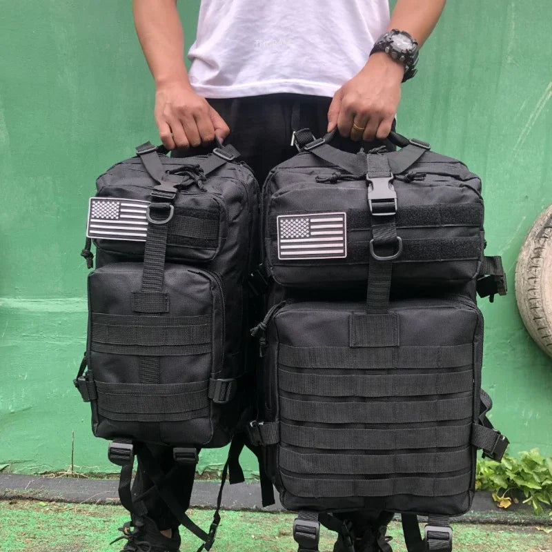 Tactical MOLLE rucksack pair in black with front flap pockets, webbing straps, U.S. flag patches