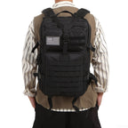Black tactical backpack with MOLLE webbing and adjustable shoulder straps, worn from back