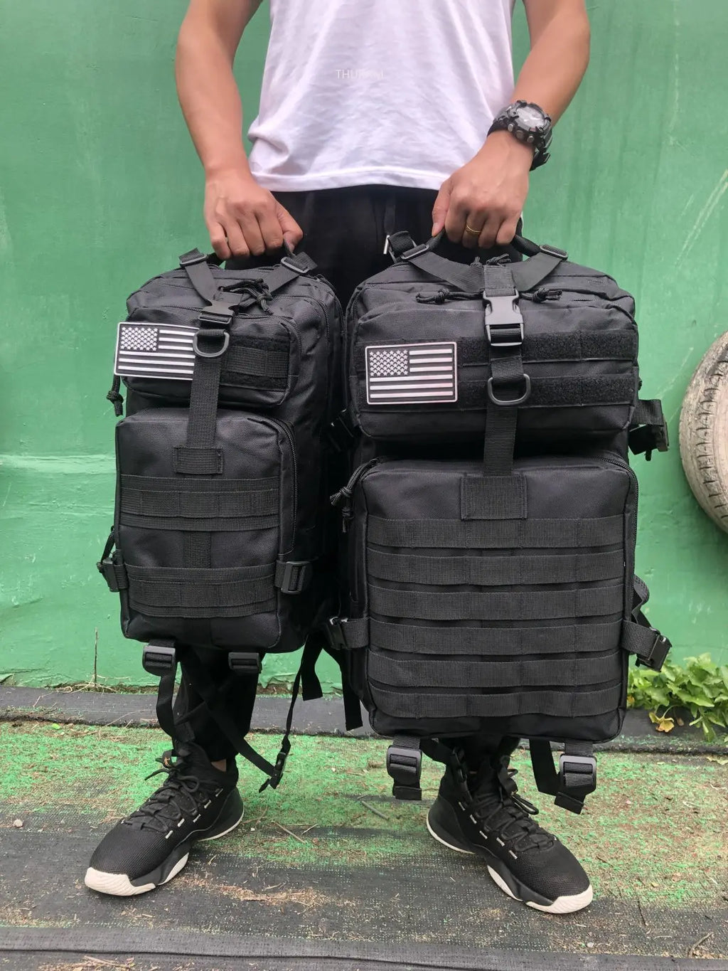 Tactical MOLLE rucksack pair in black with front flap pockets, MOLLE webbing and U.S. flag patches