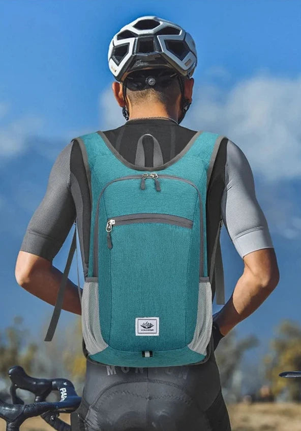 Person wearing a teal backpack with a blue sky background
