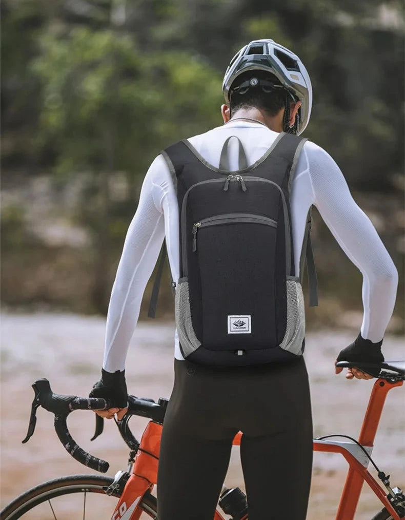Cyclist with a black backpack on a blurred natural background
