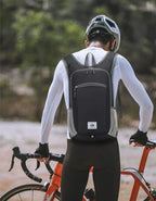Cyclist with a black backpack on a blurred natural background