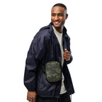 Digital camo crossbody bag worn across chest with front zipper pocket