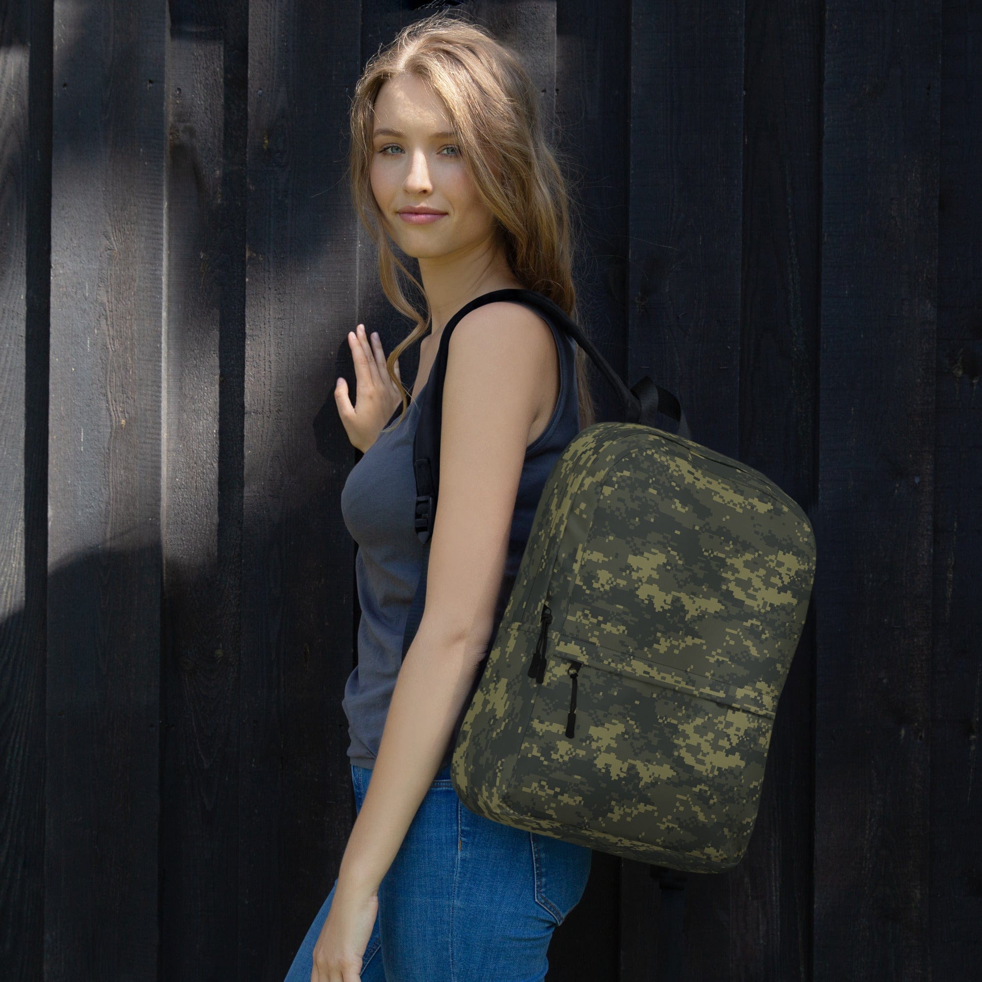 Camouflage backpack worn on shoulder with side panel and front pocket detail.