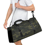 Camo green duffle bag carried with detachable shoulder strap and black end panels