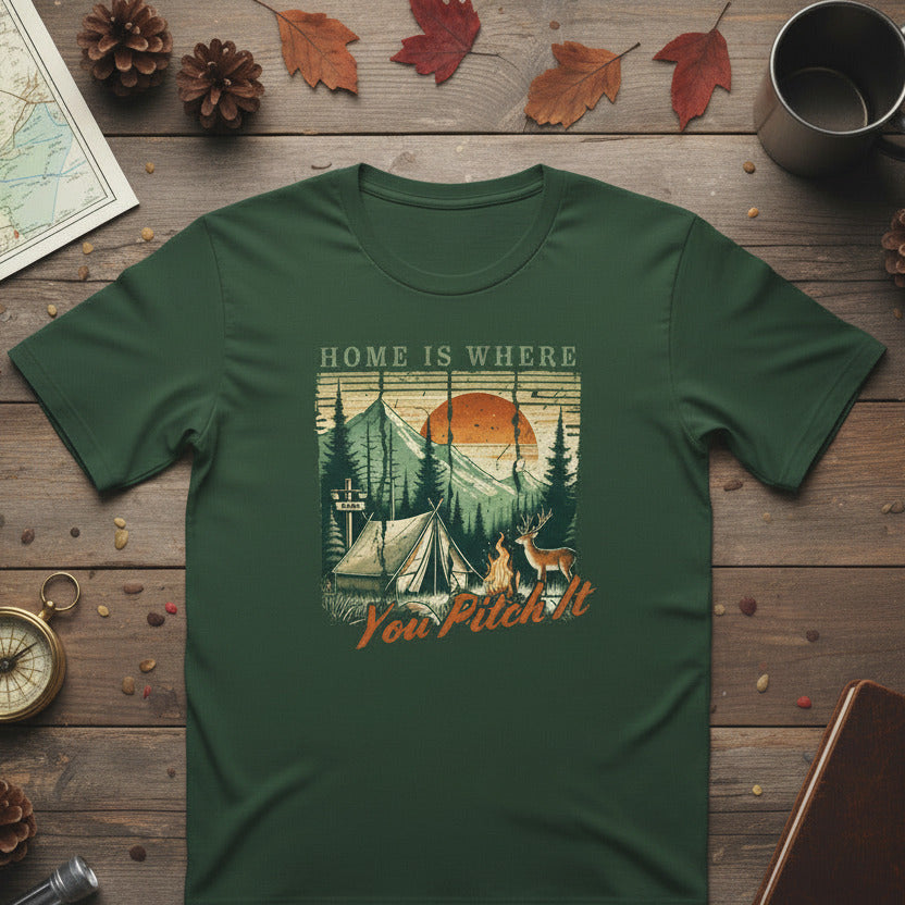 Dark green camping T-shirt with tent and pine trees graphic and “Home is where” text