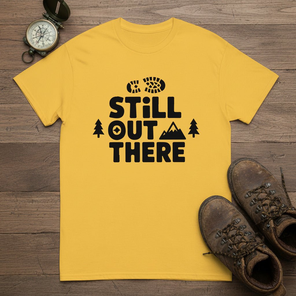 Yellow hiking T-shirt with black 'Still Out There' logo and tree graphic