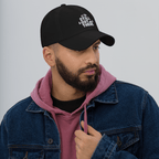 Black dad hat with embroidered “STILL OUT THERE” logo on front and curved brim.