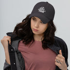 Black adjustable dad hat with embroidered “STILL OUT THERE” logo and curved brim.