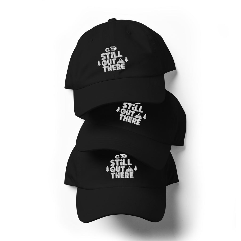 Three black dad hats with white embroidered “Still Out There” text on the front