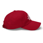 Red dad hat with white “Still Out There” embroidery on the side and adjustable strap