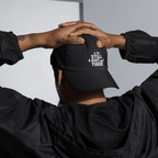 Black dad hat with embroidered “STILL OUT THERE” logo on front, adjustable back.