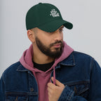 Green dad hat with embroidered “STILL OUT THERE” logo on front and curved brim.