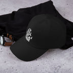 Black adjustable dad hat with white embroidered “Still Out There” logo on the front