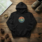 Black vintage mountain hoodie with front logo patch, kangaroo pocket, drawstring hood.