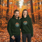 Forest green mountain hoodies on two models, front logo patches, drawstring hoods, kangaroo pockets.