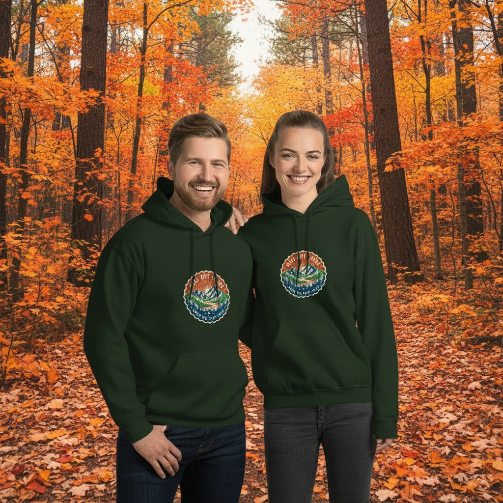 Forest green mountain hoodies on two models, front logo patches, drawstring hoods, kangaroo pockets.