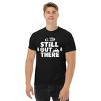 Black hiking T-shirt with large white “STILL OUT THERE” logo on the chest