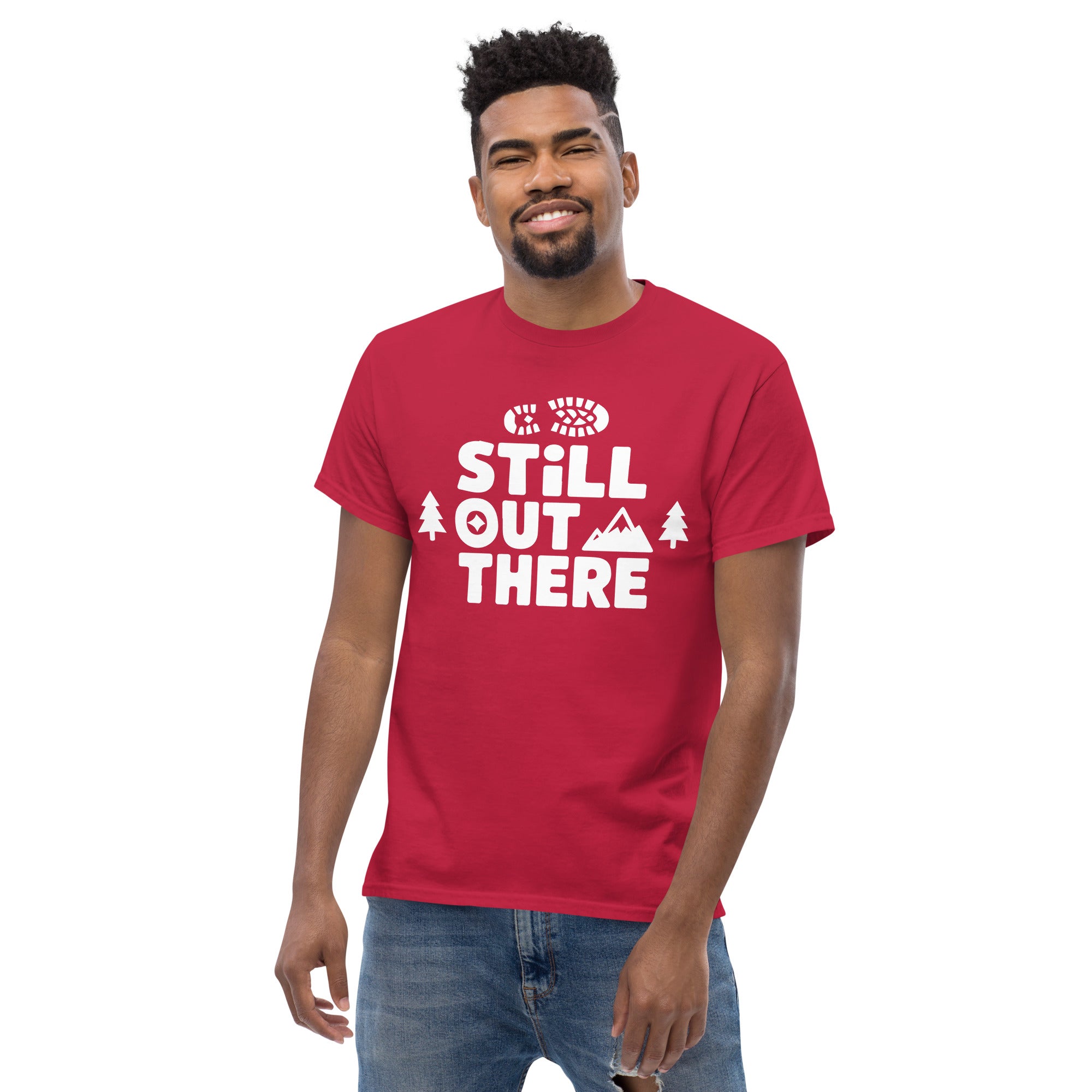 Cardinal red hiking T-shirt with white “STILL OUT THERE” logo and tree graphics