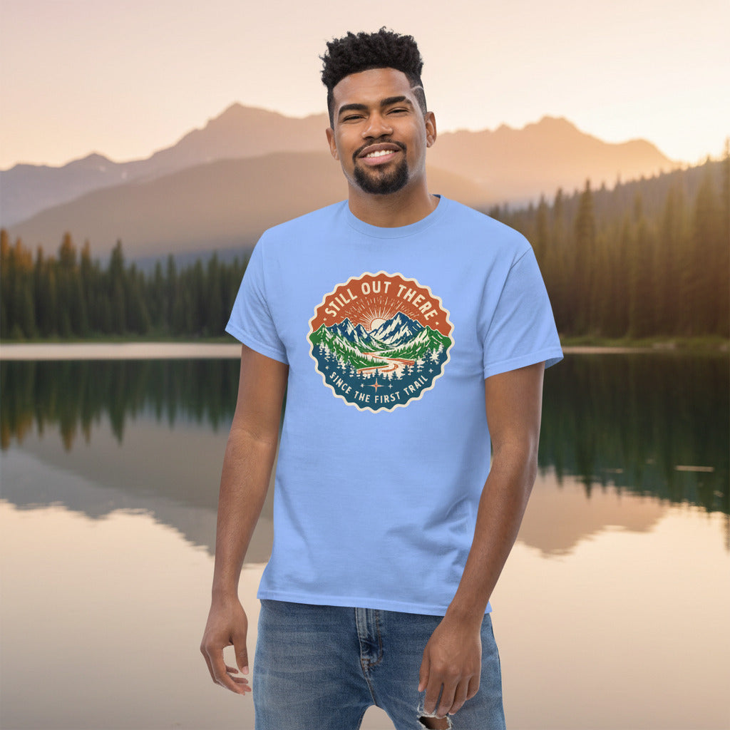 Light blue T-shirt with a circular multicolor trail badge graphic on the chest.