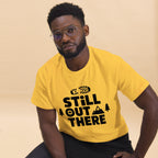Yellow hiking T-shirt with black "Still Out There" logo graphic on the chest