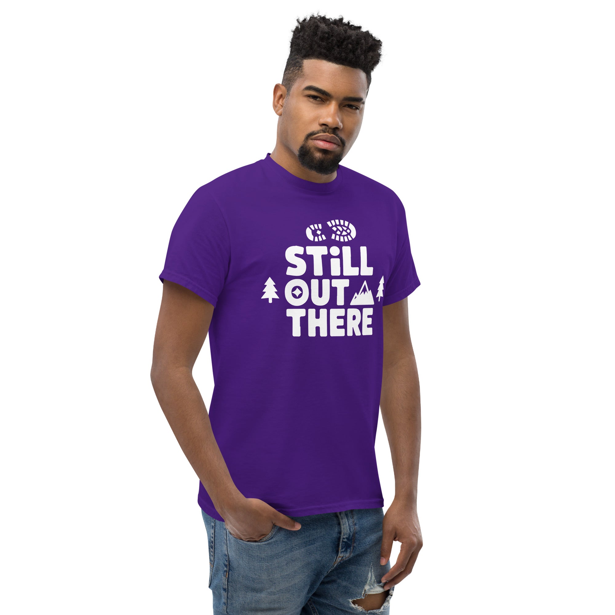 Purple hiking T-shirt with white “STILL OUT THERE” logo and mountain accents