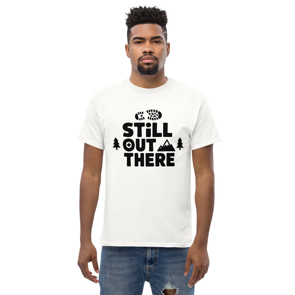 White hiking T-shirt with black “STILL OUT THERE” chest logo and trees graphic