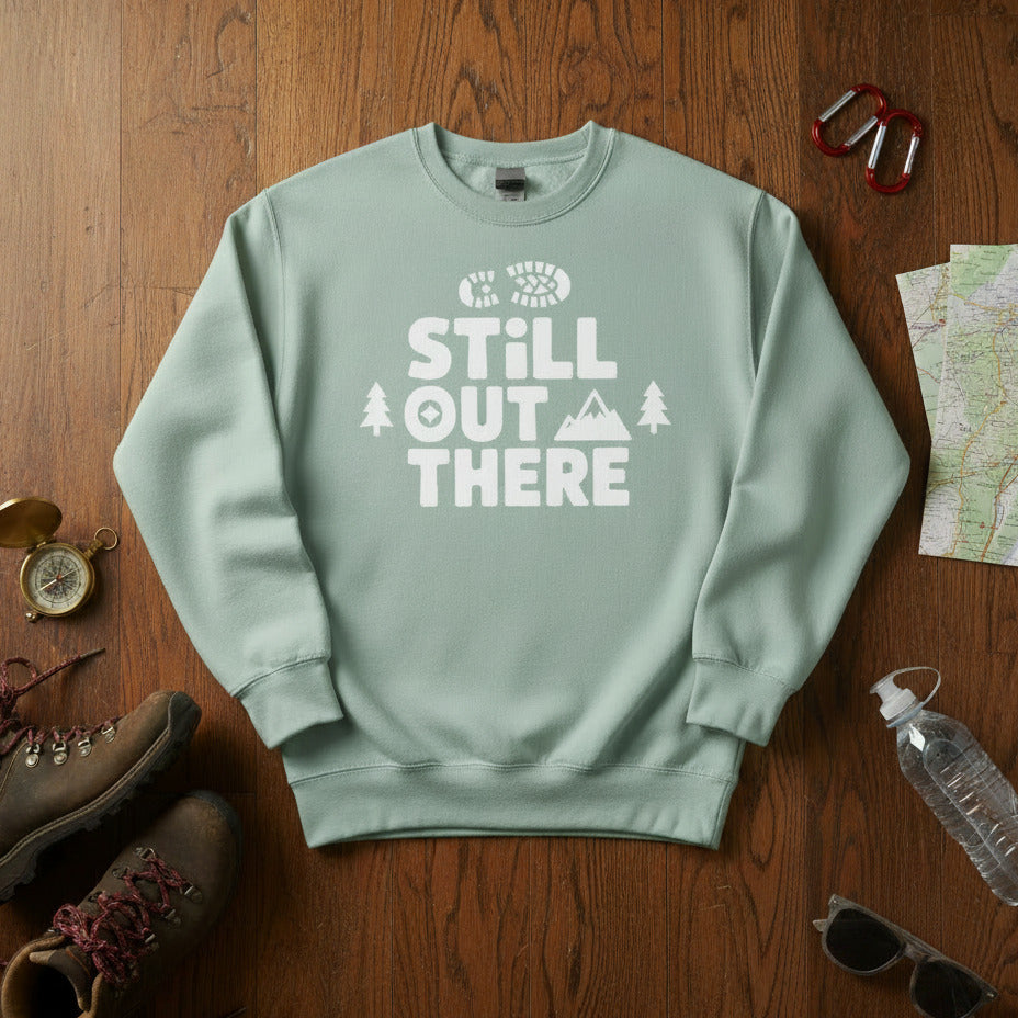 Hiking premium sweatshirt, light green with white "STILL OUT THERE" logo and tree graphic