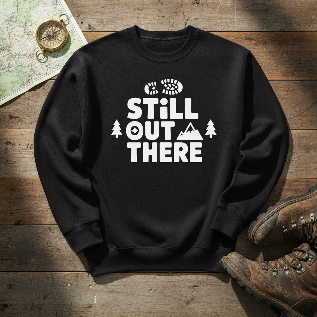 Hiking premium sweatshirt, black with white "STILL OUT THERE" logo and tree graphic
